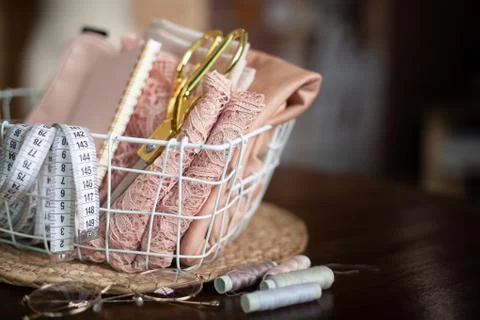 Sewing tools of tailoring scissors, tape measure, pink lace fabric in mesh Stock Photos