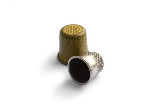 Sewing tools. Two vintage thimbles isolated on a white background with shadow. Stock Photos