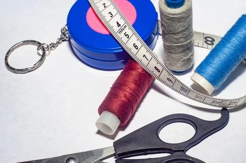 Sewing trims. spool of thread, needle, buttons, scissors and measuring tape.. Stock Photos