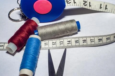 Sewing trims. spool of thread, needle, buttons, scissors and measuring tape.. Stock Photos