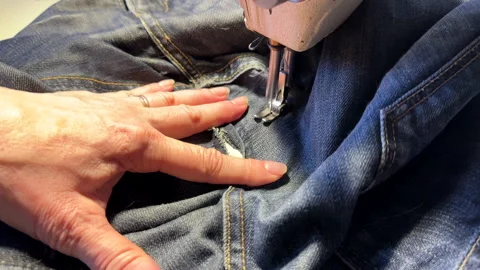 Sewing work. Stitching a hole in jeans with a sewing machine. Stock Footage 255925502