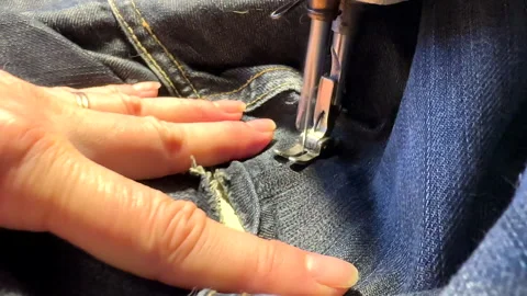Sewing work. Stitching a hole in jeans with a sewing machine. Stock Footage 255925956