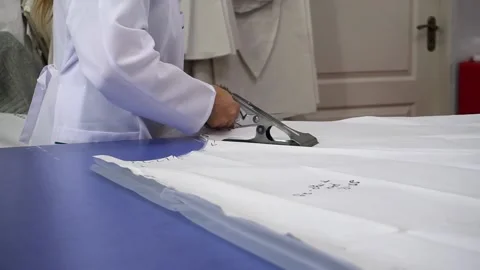 A sewing worker cuts fabric with scissors at a women's dress factory Stock Footage 140145000