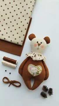 Sewing workspace with handmade teddy bear and craft supplies Stock Photos