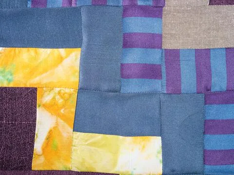Sewn patchwork cloth from blue and yellow fabrics Stock Photos