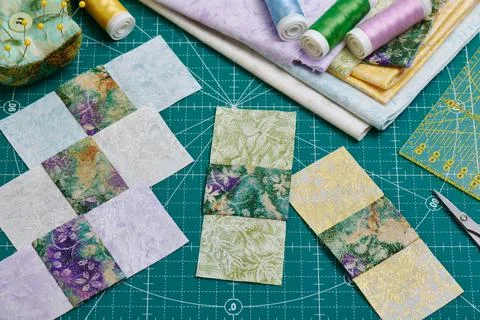 Sewn square fabric pieces, a stack of fabrics, sewing and quilting accessories Stock-Fotos