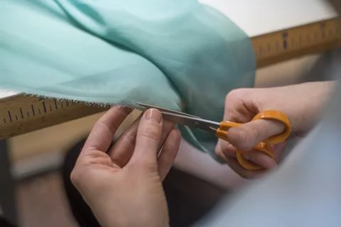 Sews clothes girl cutting material Stock Photos