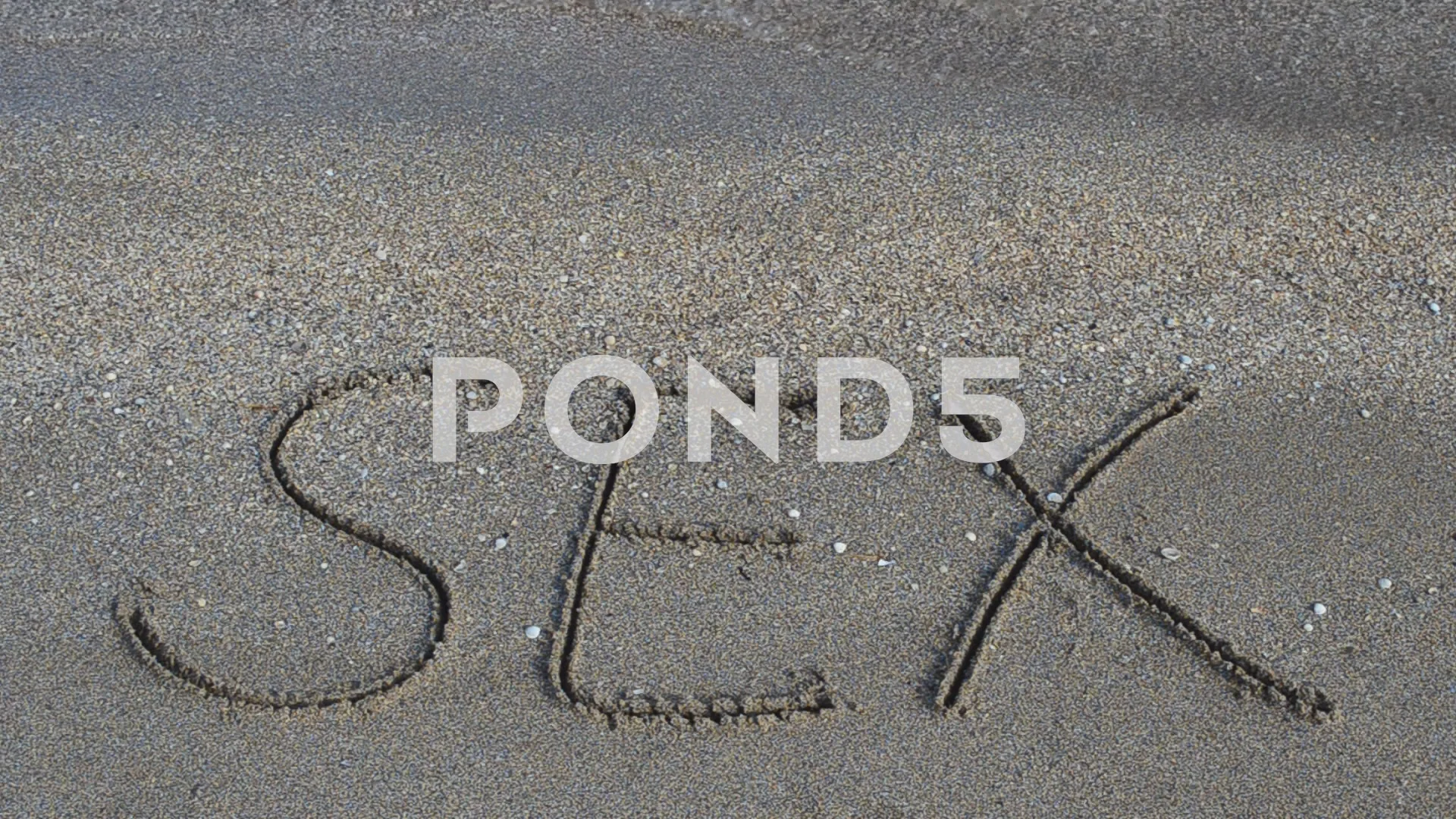 sex handwritten in sand on a beach