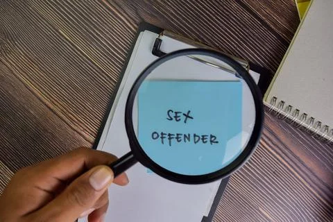 Sex Offender write on sticky notes isolated on Wooden Table. Stock Photos