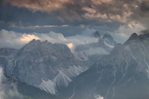 Sexten Dolomites in clouds illuminated by setting sun in Italy Stock Photos