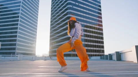 Sexy aggressive young talented mixed race woman dancing on roof top at sunset 4K Stock Footage 254043328