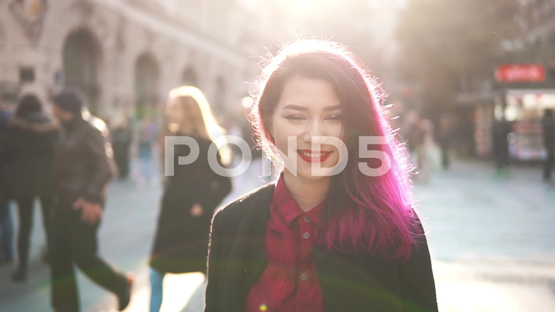 Sexy asian hipster looks at the camera and smiling in the middle of a  crowded