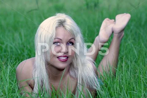 Sexy blonde lying in a grassy field (2) Stock Photos