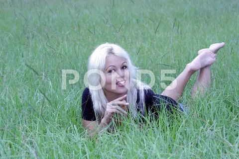 Sexy blonde lying in a grassy field (8) Stock Photos