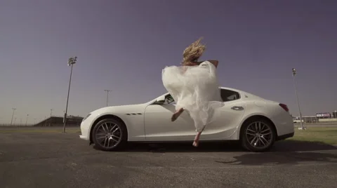 Sexy bride dances in front of her new luxury car 動画素材 61057626