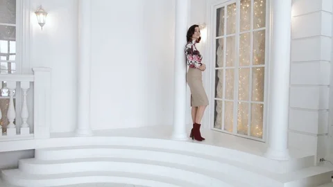 Sexy brunette posing next to the columns on the background of a high window. 스톡 동영상 102050210