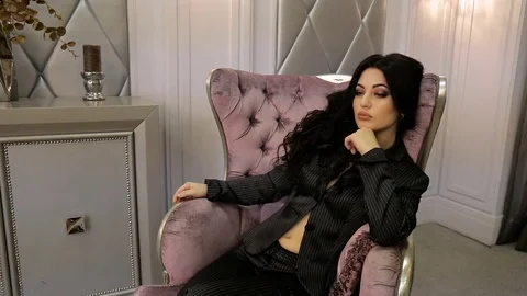 Sexy brunette posing while sitting in a chair. Full hd video Stock Footage 72791820