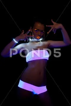 Sexy girl with glow make-up in ultraviolet light Stock Photos