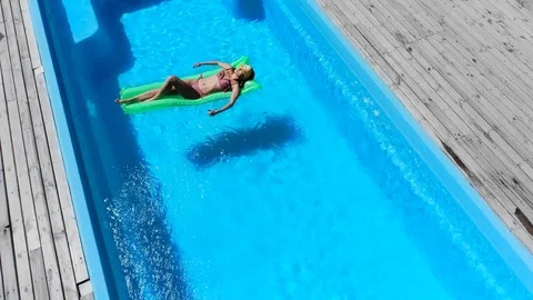 Sexy girl resting on pool float in swimming pool 動画素材 127002768
