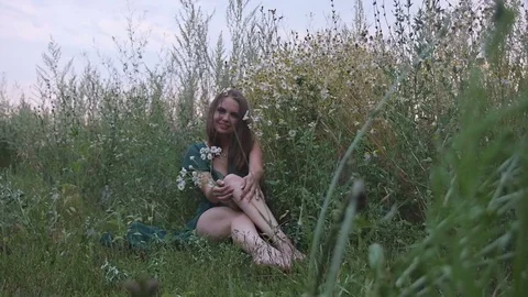 Sexy Girl Sitting in the Field With Flowers Stock Footage