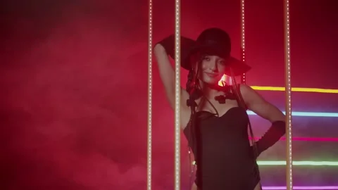 Sexy Girl Stripper in black hat is dancing in neon light slow motion. Cabaret 4K Stock Footage