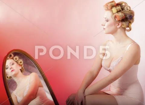 Sexy girl in underwear curlers preparing to party looking at mirror Stock Illustration