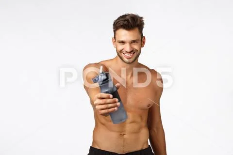 Sexy handsome and self-assured sportsman give you water bottle drink and refresh Stock Photos