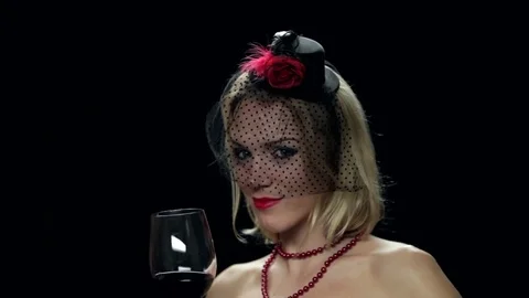 Sexy happy widow drinking red wine on black beckground Stock Footage 82635540