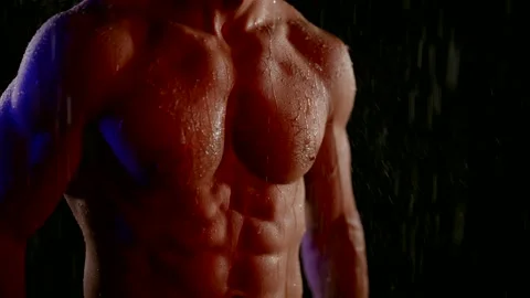 Sexy male torso in rain or shower, closeup view of tensed muscles on abdomen Stock Footage