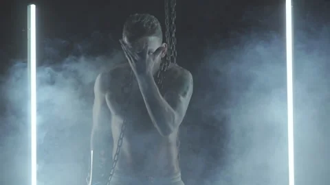 Sexy man dancing with chains in smoke Stock Footage 145883819