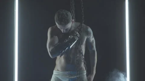Sexy man dancing with chains in smoke Stock Footage 145883879
