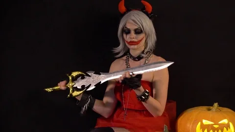 Sexy seductive devil girl makes manicure, cuts nails by sword, celebrate Stock Footage 81156762