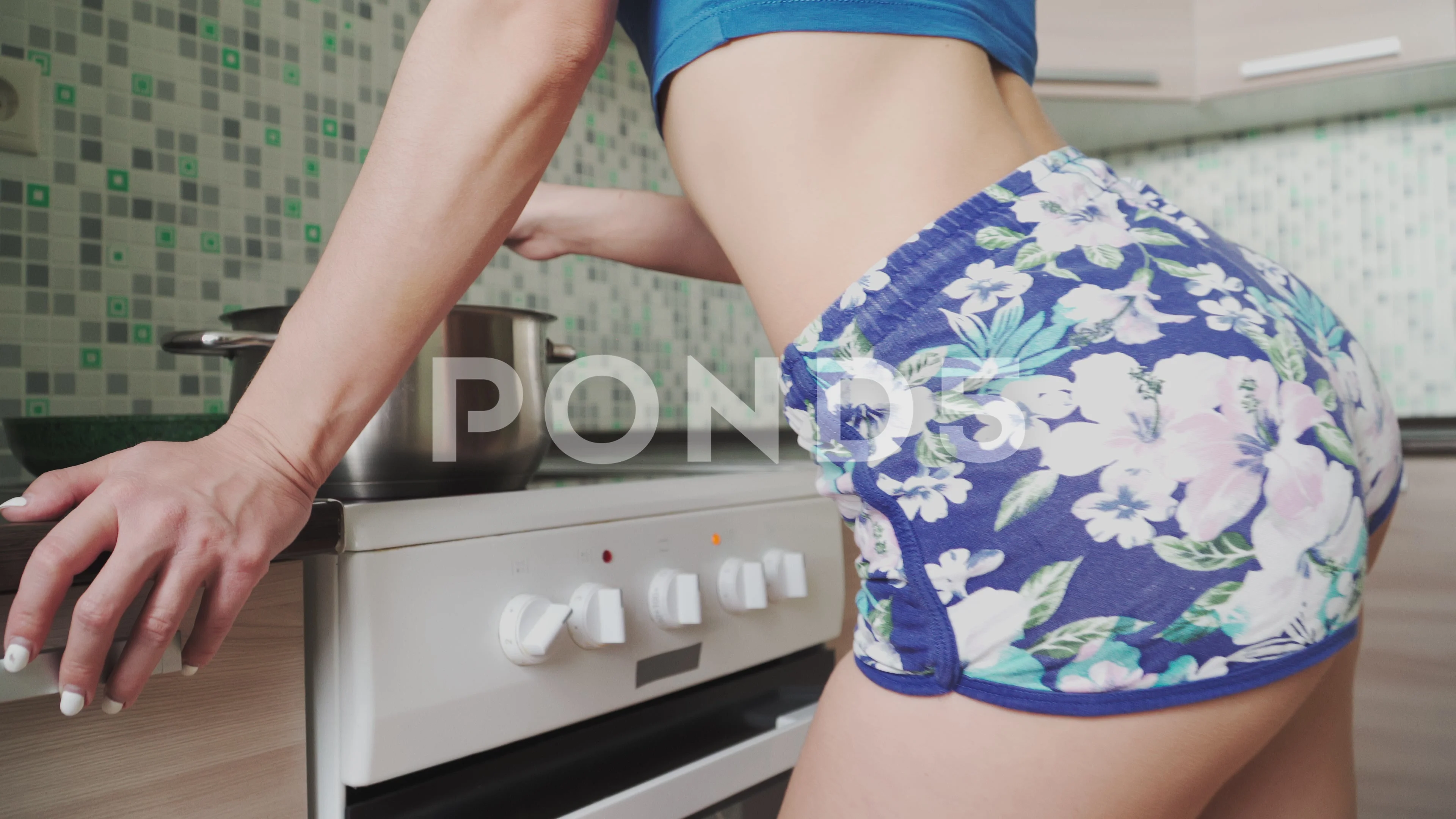 Sexy slender Girl in short shorts and topic, preparing food kitchen and  dancing