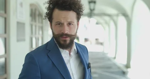 Sexy smart casual guy posing outside, holding hands on jacket button and Video stock 156542735