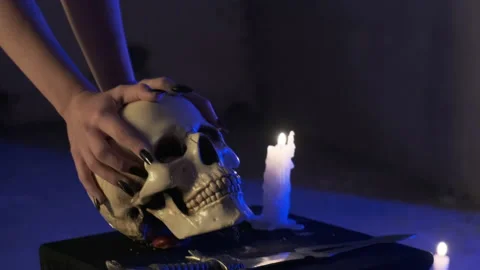 Sexy witch character holding plaster human skull in dark room. Halloween concept Stock Footage 139327676
