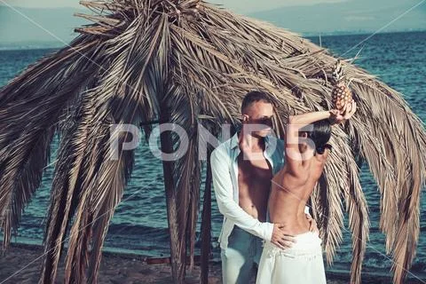 Sexy woman and man with pineapple at palm. Couple in love with sexy body relax Stock Photos