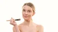 The sexy woman applying the powder on her face on the white background 4k or 4k+ Resolution