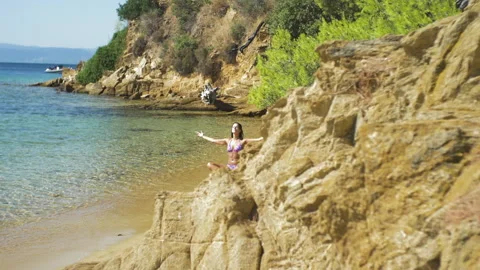 A sexy woman in bikini doing yoga on a | Stock Video | Pond5