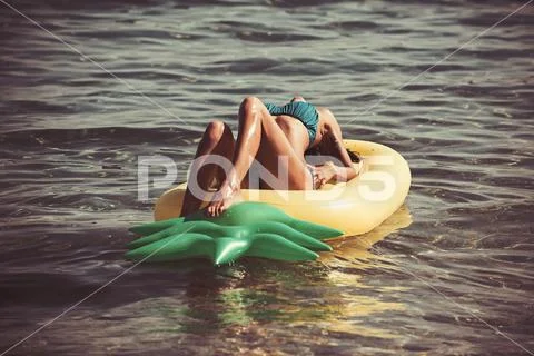 Sexy woman on Caribbean sea in Bahamas. Pineapple inflatable mattress, activity Stock Photos