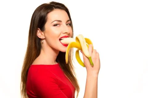 Sexy Woman in Red Clothes Eating Banana on White Background Isolated Smiling Stock Photos