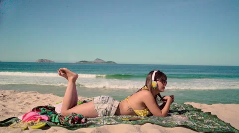 Sexy woman relaxing on beach and listening to music Stock Footage 59441465