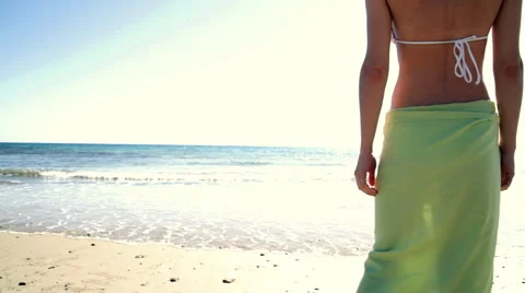 Sexy woman in sarong standing on the beach Stock Footage