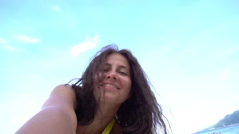 Sexy woman taking selfie using phone on beach smiling, enjoying vacation Stock Footage