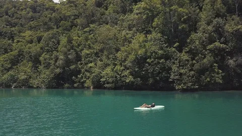 Sexy young brunnette lying down on a paddle board in the middle of atoll lagoon. Stock Footage 116404230