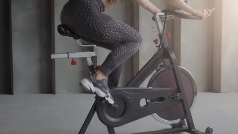Sexy young woman using a exercise bike. Attractive young woman at the gym riding Stock Footage 111156141