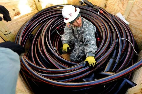 Sgt. Muy Thor inspects a large generator cable before installing it at a f... Stock Photos