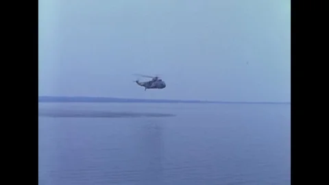 SH-3A helicopter approachs over water to pick up a pilot out of the water and Stock Footage 117053903
