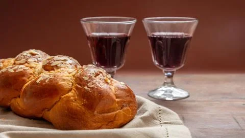 Shabbat concept, challah bread with two glasses of red wine on wooden table Foto stock