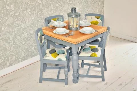 Shabby chic dining table with chairs and tableware Stock Photos