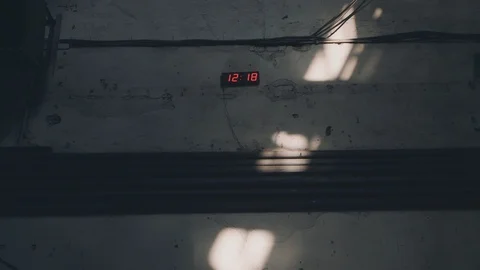 Shabby wall with a digital clock, shows noon. Sunbeam on shabby wall Stock Footage 88392159